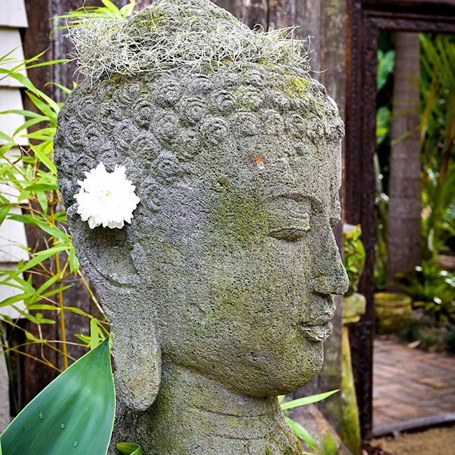 Serene Buddah head statue with flower in hair