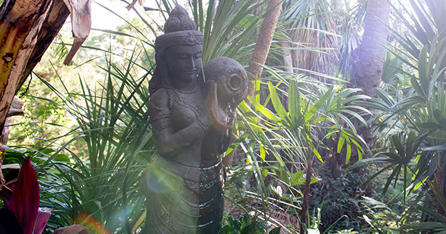 Statue surrounded by sub-tropical bushland